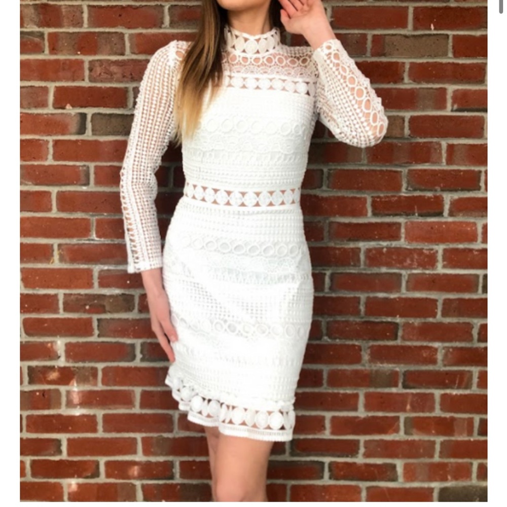 White lace dress with intricate details and long sleeves